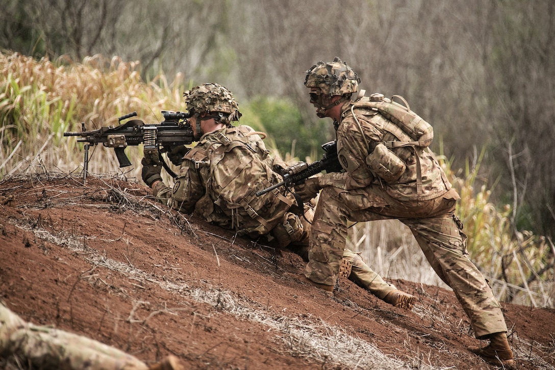 A soldier yells out fire commands to a M249 gunner during a combined arms live-fire exercise.