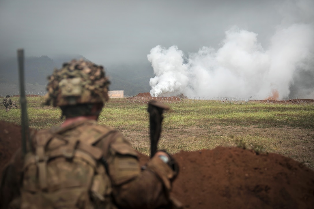 A soldier looks toward his team’s follow-on objective during a combined arms live-fire exercise.
