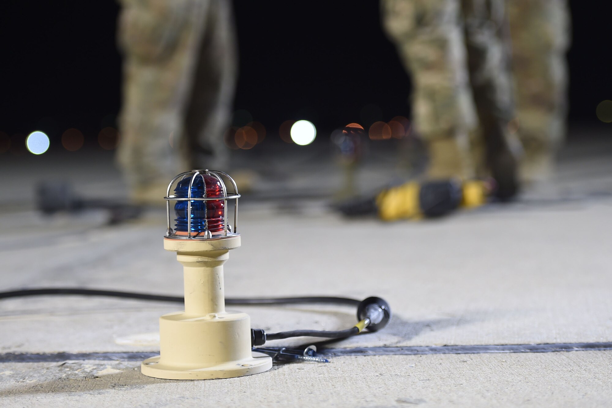 A light sits on the flightline at night