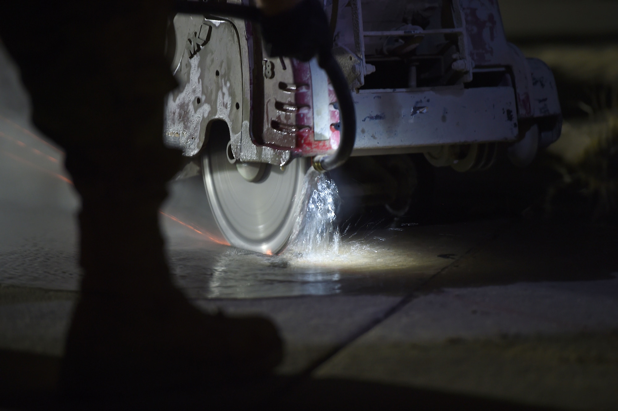 A drill cuts through the runway at night time