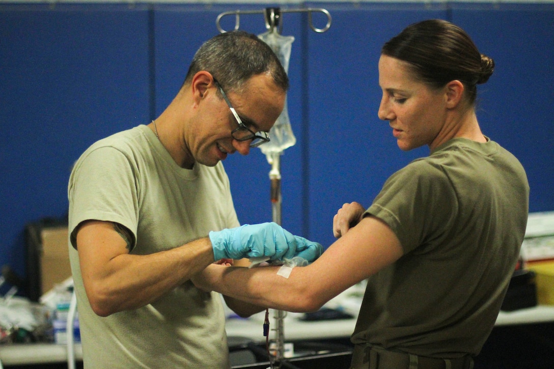 Medic removes IV from patient's arm.