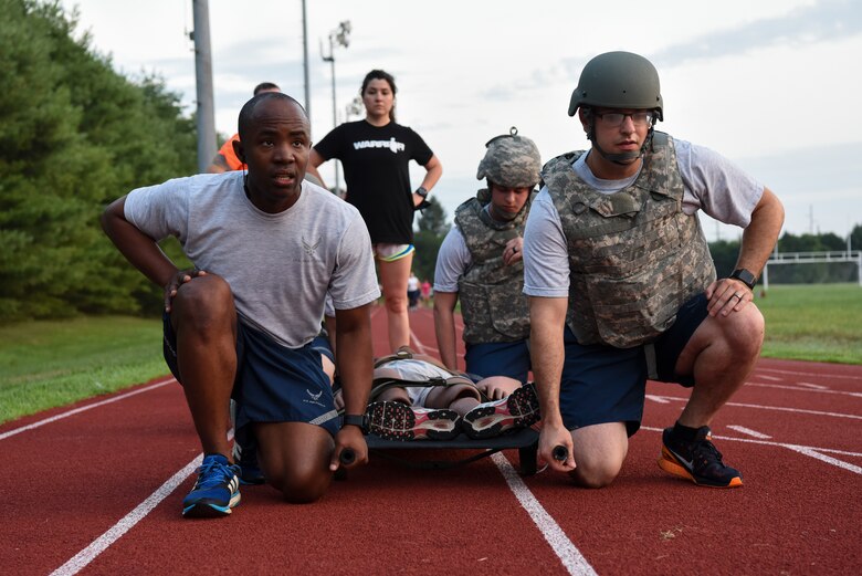 Medics assigned to the 436th Medical Group prepare to lift a litter supporting a training dummy July 30, 2018, at Dover Air Force Base, Del., in preparation for the annual Emergency Medical Technician Rodeo at Cannon AFB and Melrose Air Force Range, N.M. The competition was designed to test how EMT teams respond to real-world scenarios in both home station and deployed environments. (U.S. Air Force photo by Staff Sgt. Aaron J. Jenne)