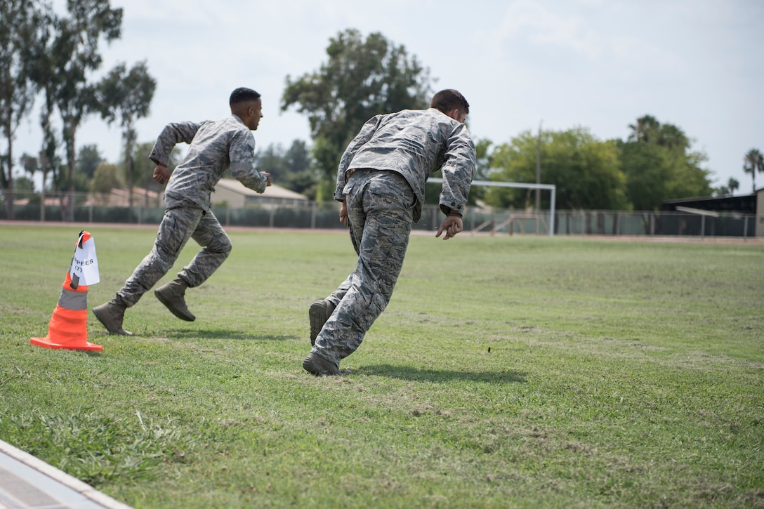 Airmen run to the next obstacle during an obstacle course.