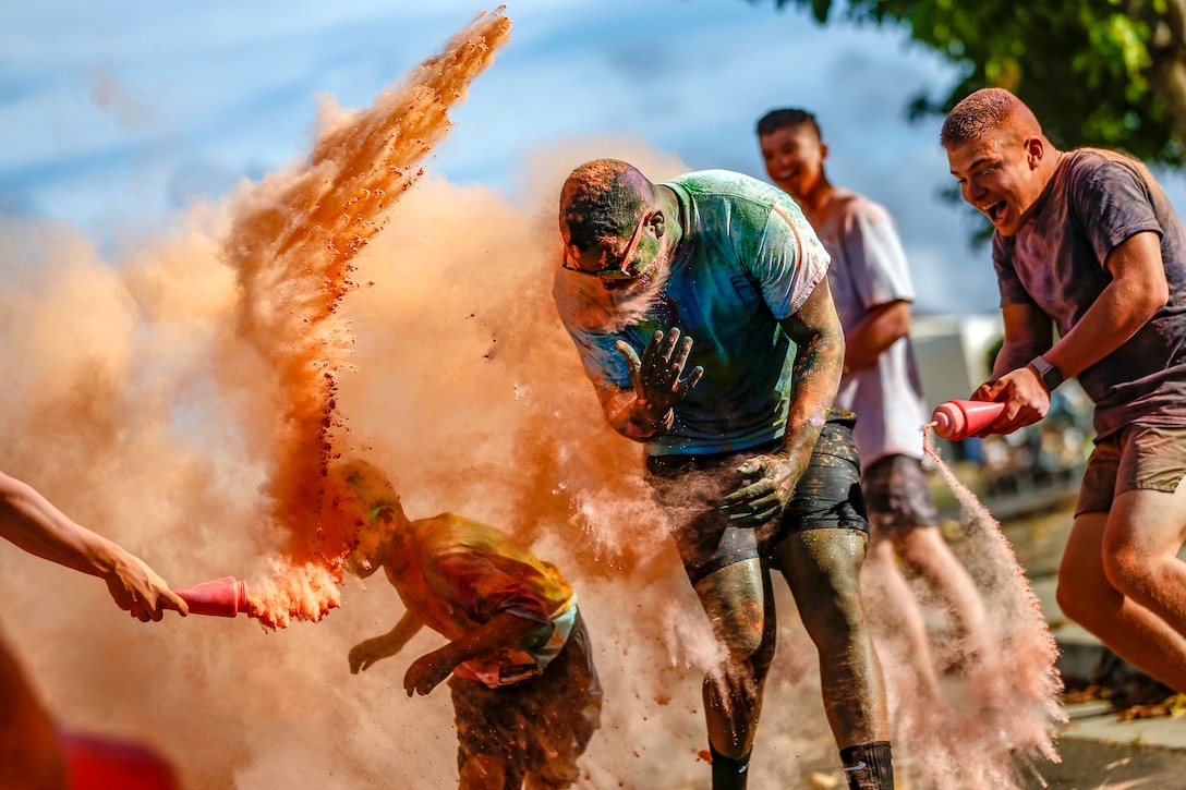 Color run participants run through clouds of colored powder.