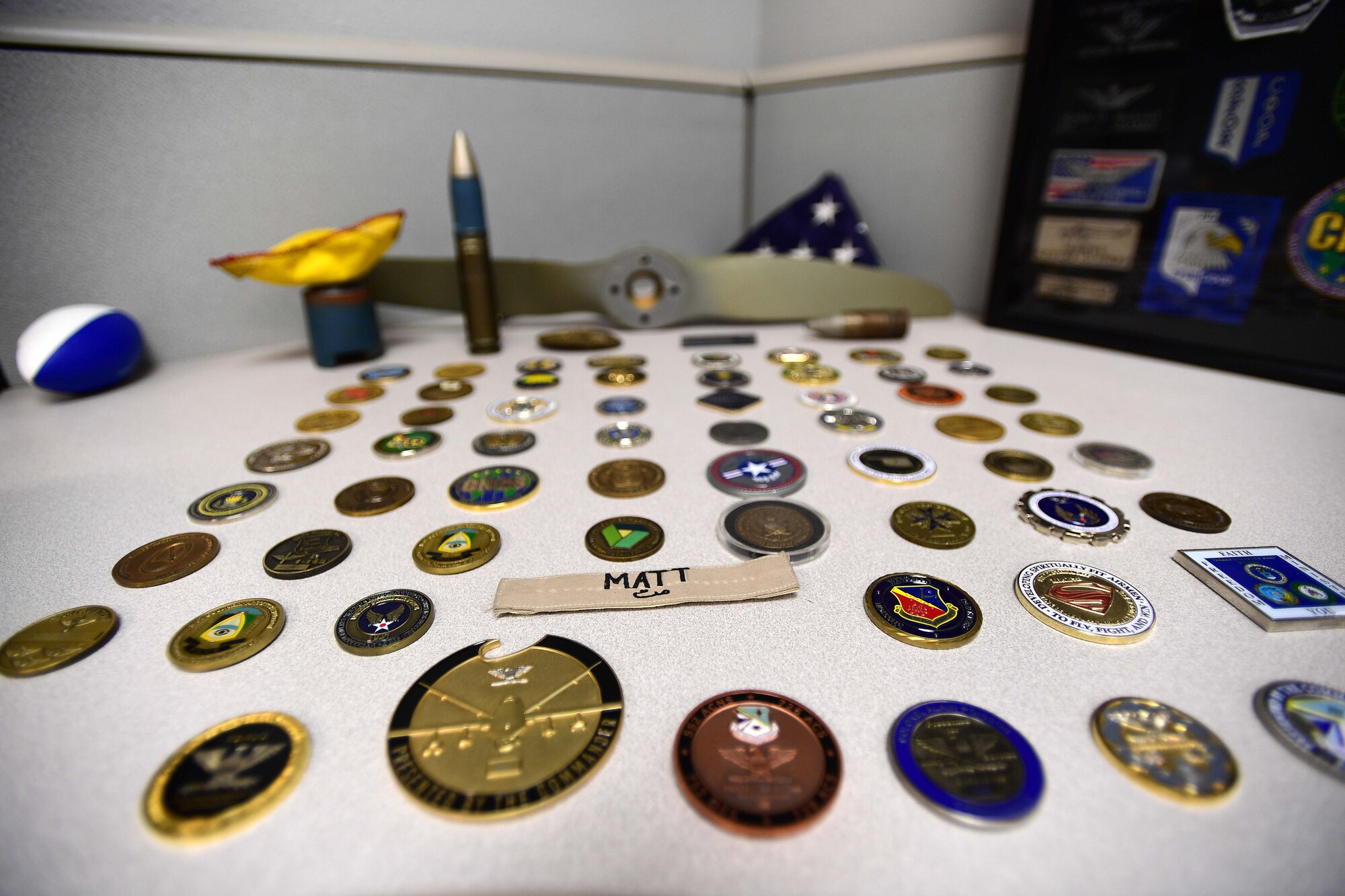 Chaplain Matthew’s coins tell a story from the early part of his 25-year career starting U.S. Army as an infantryman, honor guardsman, and Apache helicopter pilot prior to becoming a U.S. Air Force Chaplain. He now leverages his combat experience to further help combat Airmen at Creech Air Force Base, Nev. (U.S. Air Force photo by Senior Airman Christian Clausen)