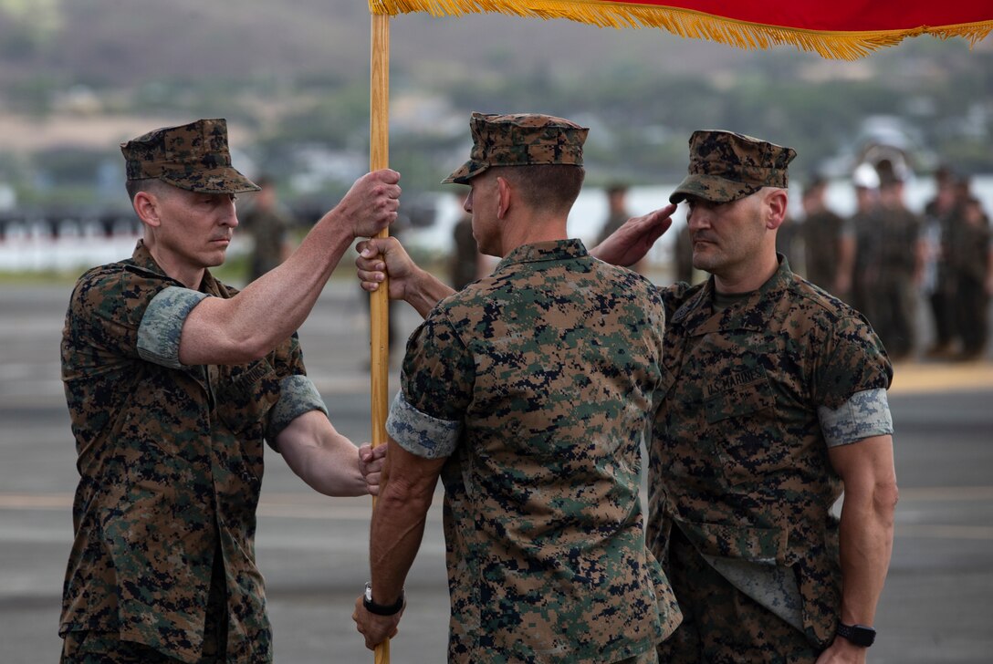 U.S. Marine Corps Lt. Col. Frank Makoski, center, off-going commanding officer, Marine Light Attack Helicopter Squadron (HMLA) 367, Marine Aircraft Group 24, 1st Marine Aircraft Wing, passes the unit's battle colors to Lt. Col. Brain Grant, left, on-coming commanding officer during the HMLA-367 Change of Command Ceremony, Marine Corps Base Hawaii, Aug. 3, 2018. Lt. Col. Makoski relinquished command to Lt. Col. Grant. (U.S. Marine Corps photo by Sgt. Alex Kouns)