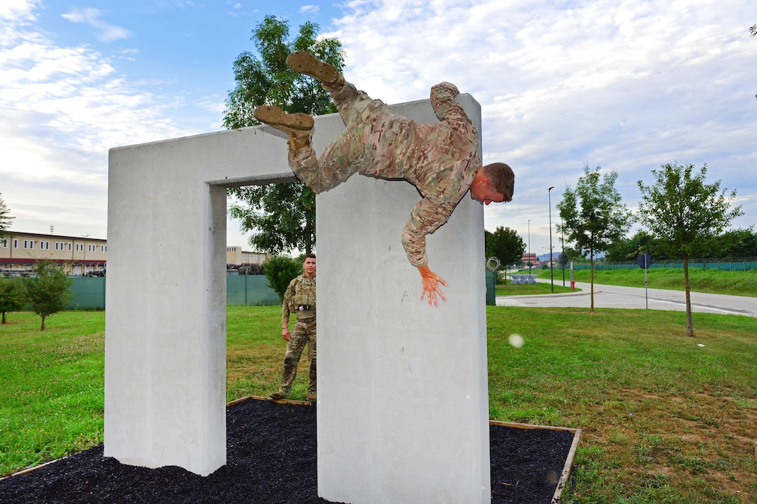 Commander maneuvers through a simulated window during the obstacle course.