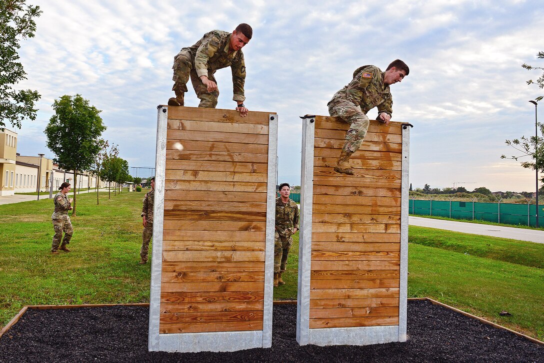 Soldiers leaps over a wall during the obstacle course.