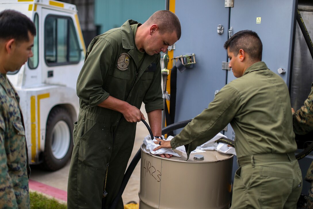 LCpl. Nevada Ryan, a diesel hydraulic electrician, attempts to plug an airway while filling an oil pump during Exercise Northern Lightning at Volk Field Counterland Training Center, Camp Douglas, Wis. Aug. 16. Exercise Northern Lightning 2018 allows the Air Force, Marine Corps and Navy to strengthen interoperability between services and gives the different branches a greater understanding of aviation capabilities within a joint fighting force. (U.S. Marine Corps photo by Sgt. David Bickel)