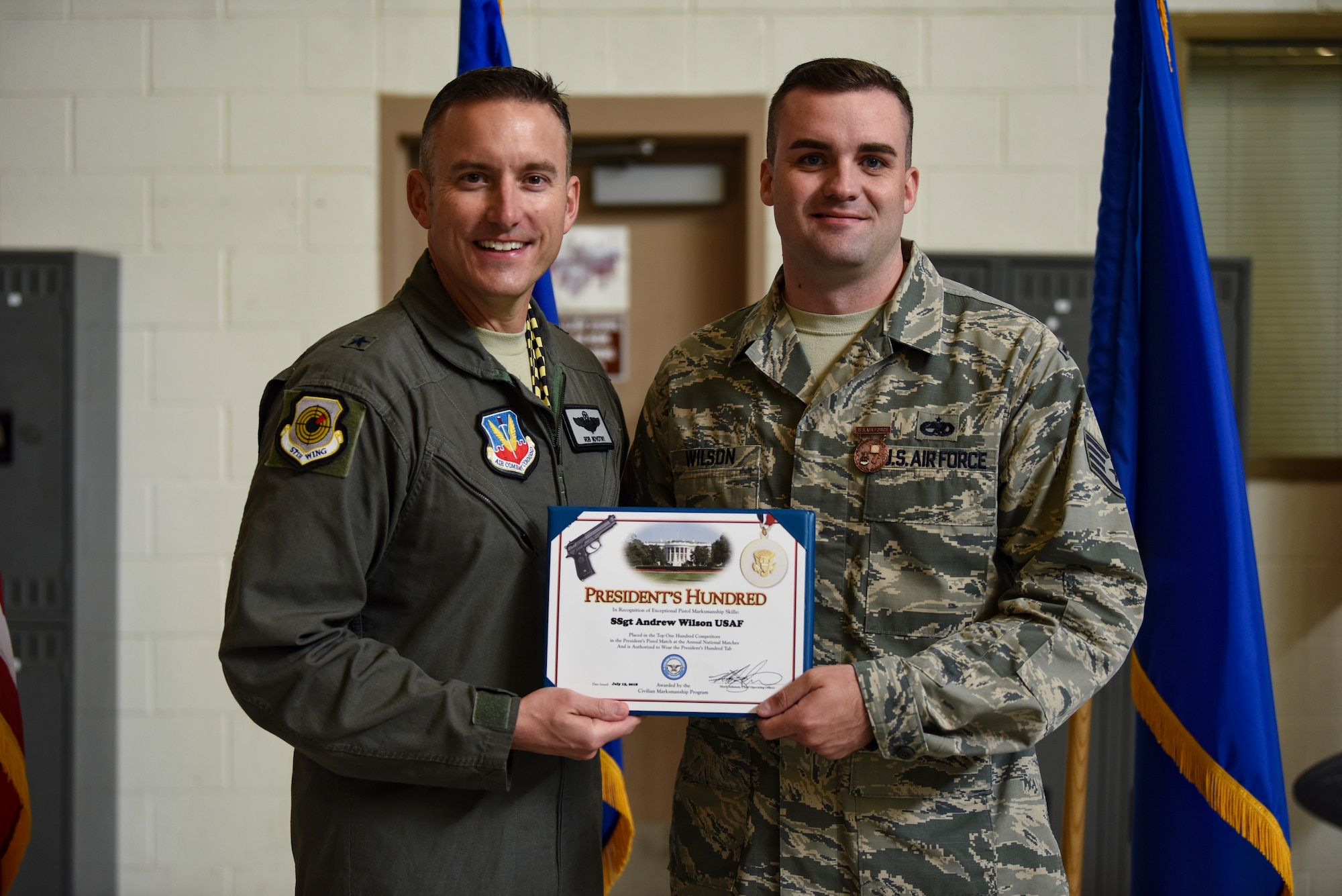 Brig. Gen. Robert G. Novotny, 57th Wing commander, presents the President’s Hundred award to Staff Sgt. Andrew Wilson, 757th Aircraft Maintenance Squadron Strike Aircraft Maintenance Unit F-15E Strike Eagle fighter jet crew chief, at Nellis Air Force Base, Nevada, Aug. 15, 2018. Wilson earned the President’s Hundred tab after shooting a perfect score at the 2018 National Trophy Pistol Matches and Small Arms Firing School at Camp Perry, Ohio. (U.S. Air Force photo by Airman 1st Class Andrew D. Sarver)