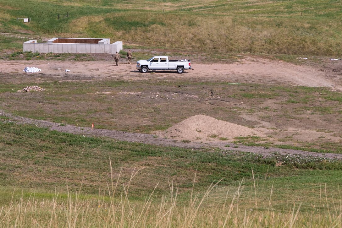 Two 28th Civil Engineer Squadron explosive ordnance disposal technicians retrieve an explosively engraved plaque after a controlled detonation at Ellsworth Air Force Base, S.D., Aug. 17, 2018. The plaque was engraved in honor of Staff Sgt. Bryan D. Berky, an EOD technician deployed from Ellsworth AFB who was killed in action on Sept. 12, 2009, while serving in the western province of Farah, Afghanistan. The base EOD range was named in his honor. (U.S. Air Force photo by Tech. Sgt. Jette Carr)