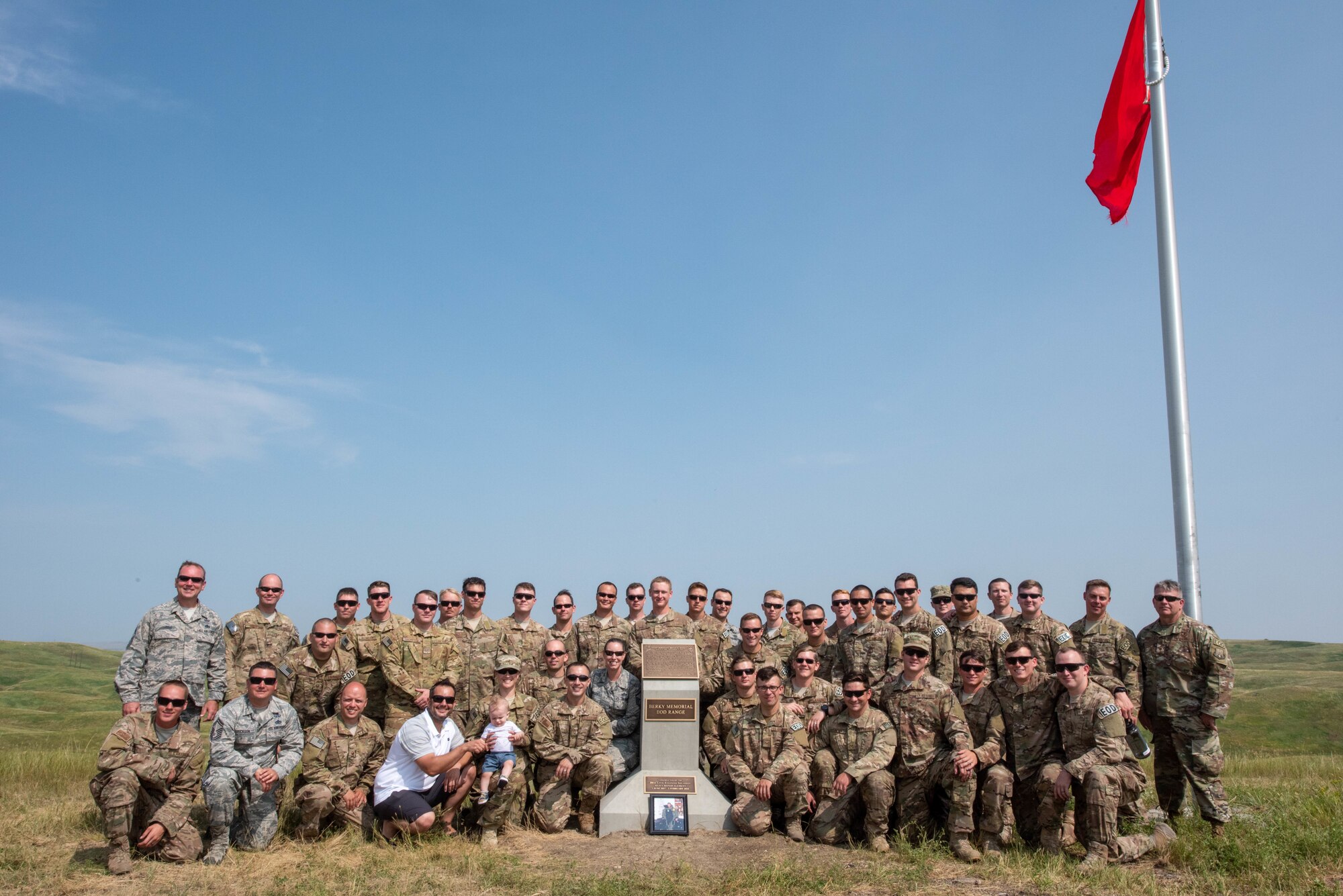 The 28th Civil Engineer Squadron explosive ordnance disposal flight and visiting EOD members stand next to a memorial plaque for Staff Sgt. Bryan D. Berky following an EOD range dedication ceremony at Ellsworth Air Force Base, S.D. Aug. 17, 2018. The range was named in honor of Berky, an EOD technician deployed from Ellsworth AFB who was killed in action on Sept. 12, 2009, while serving in the western province of Farah, Afghanistan. (U.S. Air Force photo by Tech. Sgt. Jette Carr)