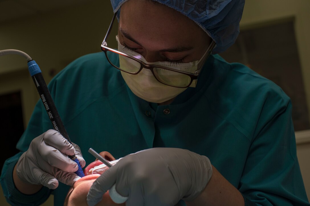 U.S. Air Force Senior Airman Courtney Lott performs a routine dental cleaning on Airman 1st Class Ana Karen Lemieux, both 35th Dental Squadron dental technicians, at Misawa Air Base, Japan, Aug. 17, 2018. While friends and family remain a solid support system for Lott, she also credits the military for her success as a parent and individual. (U.S. Air Force photo by Airman 1st Class Collette Brooks)