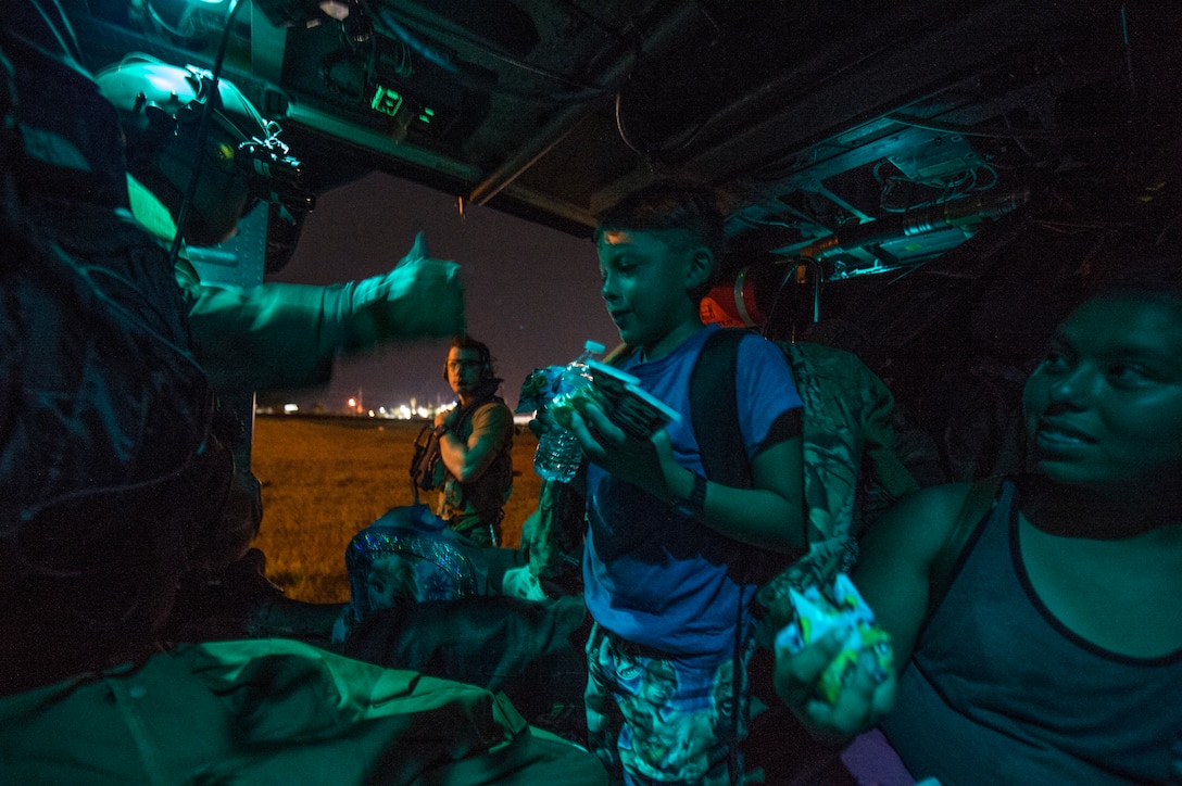 U.S. Air Force Master Sgt. Robert Alavarado, 41st Rescue Squadron special mission aviator, gives evacuees food and water after being rescued from their home due to flooding and destruction left by Hurricane Harvey in the Houston Texas area, Aug. 31, 2017. Hurricane Harvey formed in the Gulf of Mexico and made landfall in southeastern Texas, bringing record flooding and destruction to the region. U.S. military assets supported FEMA, as well as state and local authorities in rescue and relief efforts. (U.S. Air Force photo by Staff Sgt. Keith James)