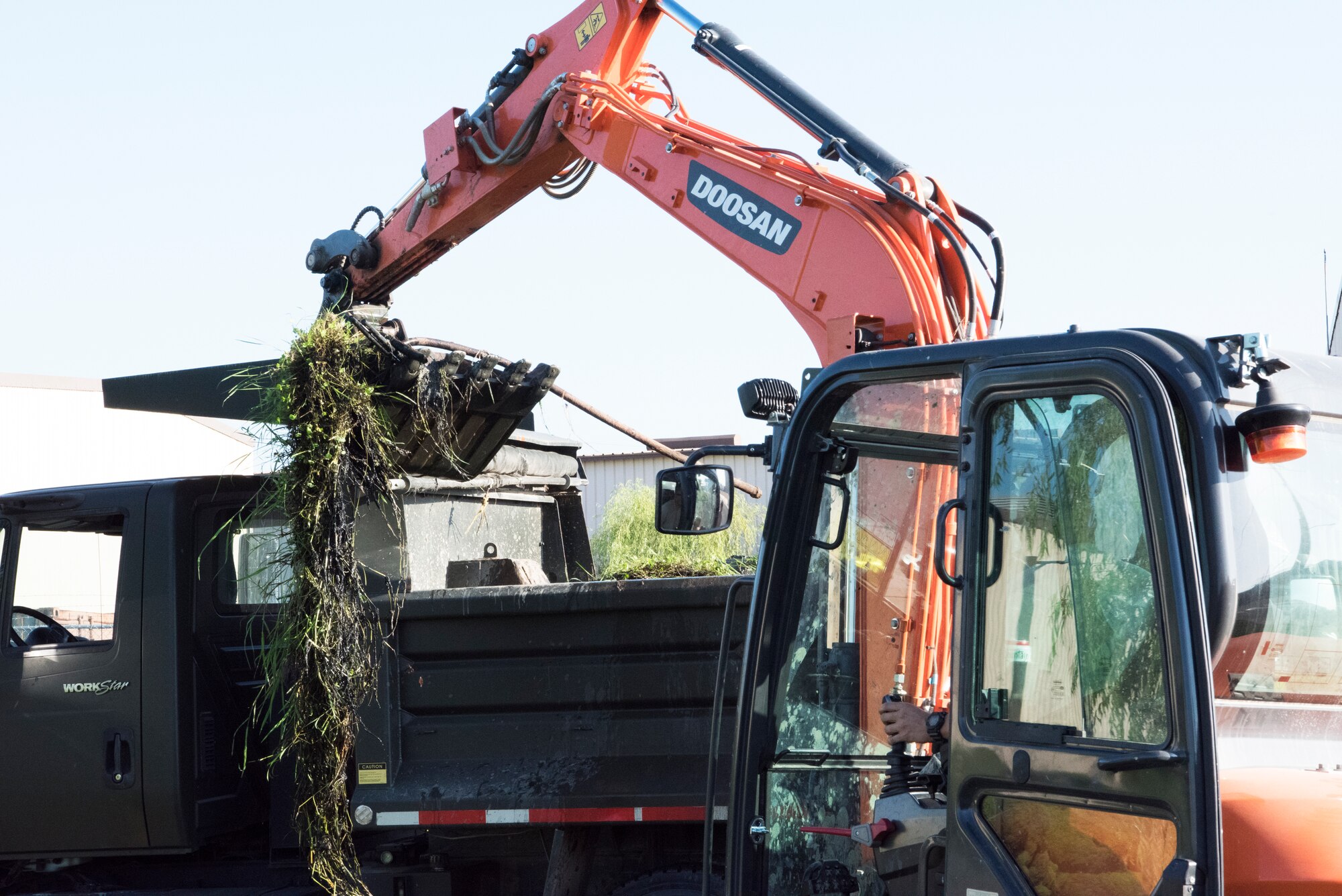 U.S. Air Force Senior Airman Kyle Gibson, 8th Civil Engineer Squadron pavements and equipment operator, uses a backhoe to clear debris from a storm drain in preparation for Typhoon Soulik at Kunsan Air Base, Republic of Korea, Aug. 22, 2018. The impact storms like Soulik have on 8th Fighter Wing operations is minimized by extensive readiness planning and preparation. (U.S. Air Force photo by Staff Sgt. Levi R. Rowse)