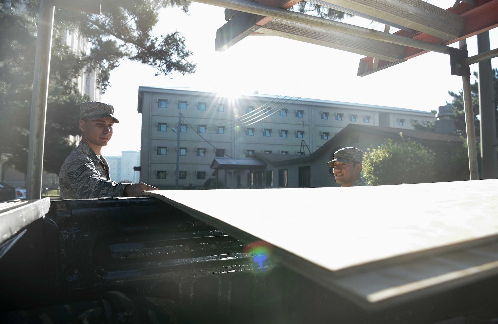 U.S. Air Force Staff Sgt. Matthew Brown (left), 8th Civil Engineer Squadron structural journeyman, and Staff Sgt. Ronald Jay Tabago (right), 8th CES operations management, lift a sheet of plywood from a truck to board up the Base Chapel’s windows at Kunsan Air Base, Republic of Korea, Aug. 22, 2018. As Typhoon Soulik approaches the Korean peninsula, Airmen assigned to the 8th Fighter Wing prepare the air base to weather the storm. (U.S. Air Force photo by Senior Airman Savannah L. Waters)
