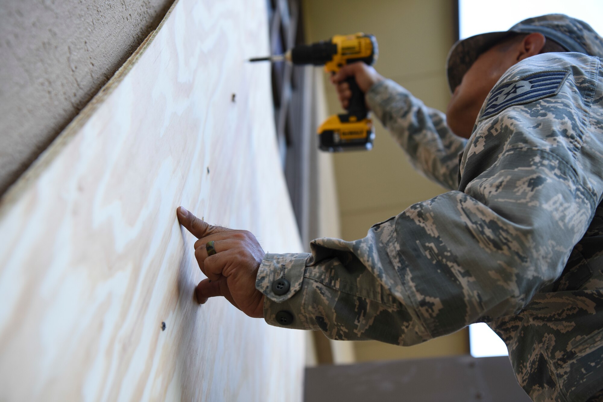 U.S. Air Force Tech. Sgt. Darlwin Langit, 8th Civil Engineer Squadron structural noncommissioned officer in charge, drills a sheet of plywood into place while boarding up a Base Chapel window at Kunsan Air Base, Republic of Korea, Aug. 22, 2018.  As Typhoon Soulik approaches the Korean peninsula, the Airmen assigned to the 8th Fighter Wing prepare the air base to weather the approaching storm. (U.S. Air Force photo by Senior Airman Savannah L. Waters)