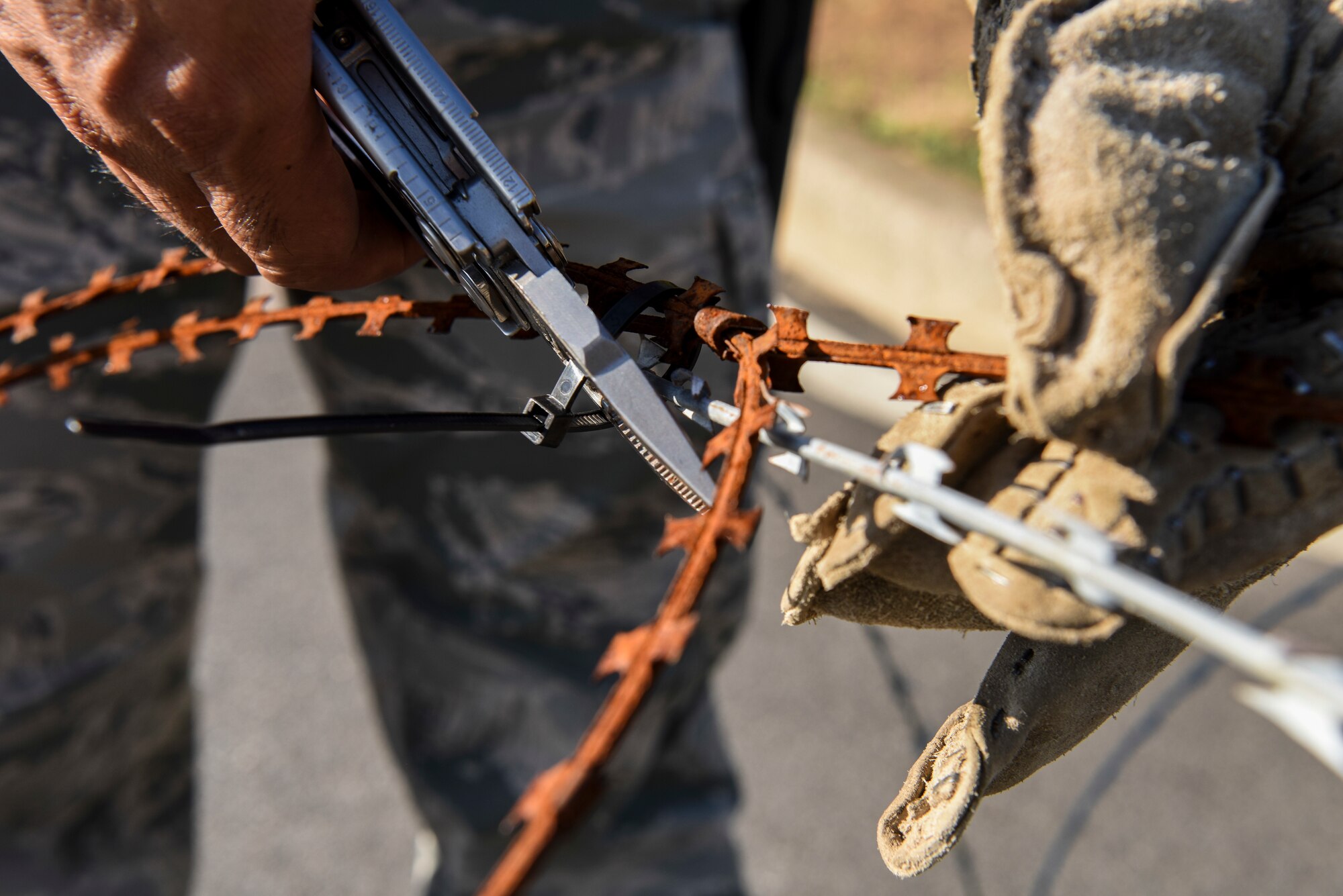 U.S. Air Force Tech. Sgt. Darlwin Langit, 8th Civil Engineer Squadron structural noncommissioned officer in charge, cuts loose wire to gather and store before the arrival of Typhoon Soulik as Kunsan Air Base, Republic of Korea, Aug. 22, 2018.  Airmen from the 8th Fighter Wing cleaned-up loose items, filled sand bags, and took other preparatory actions as Typhoon Soulik approaches the Korean peninsula. (U.S. Air Force photo by Senior Airman Savannah L. Waters)