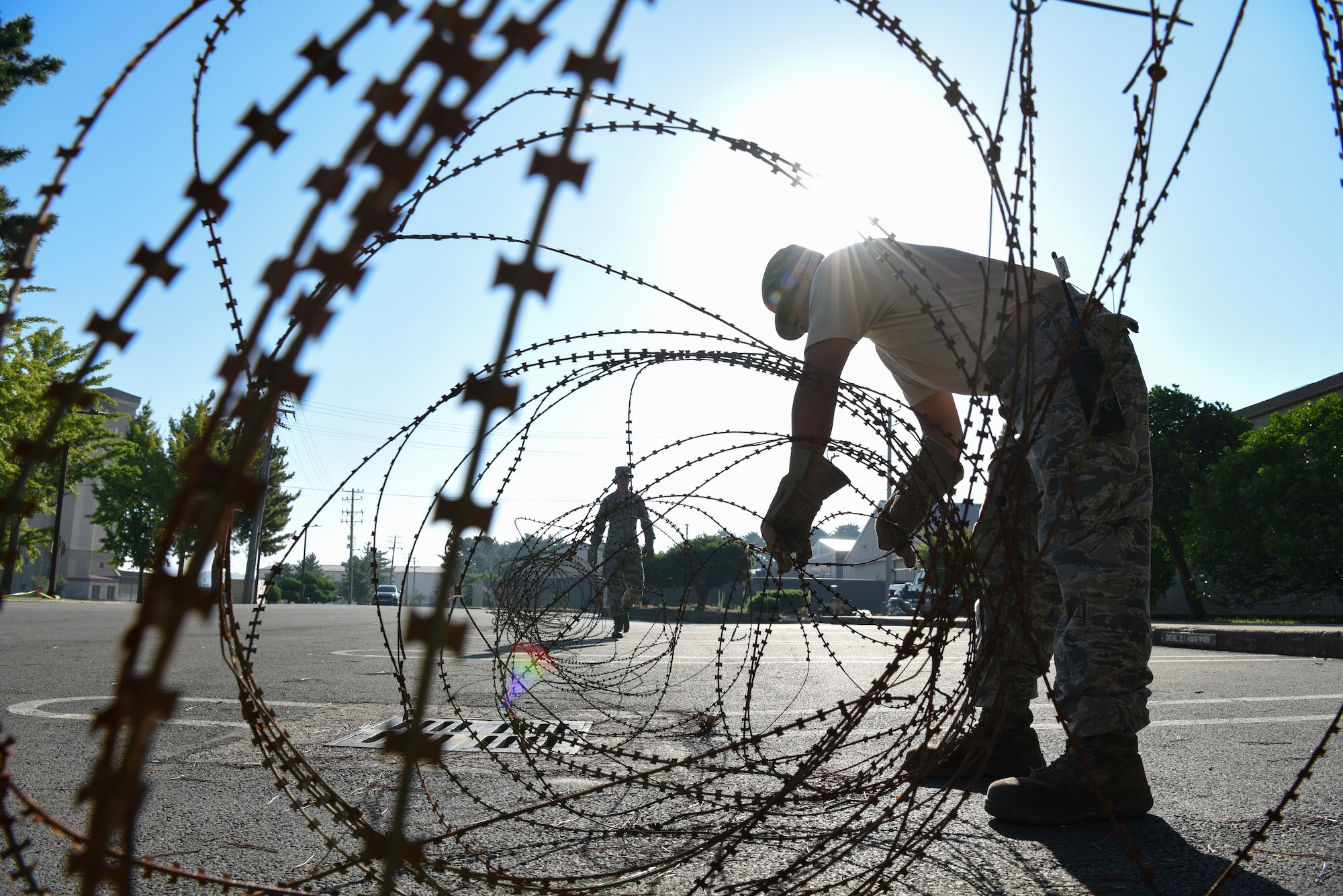 U.S. Air Force Staff Sgt. Matthew Brown (left), 8th Civil Engineer Squadron structural journeyman, and Tech. Sgt. Darlwin Langit, (right), 8th CES structural noncommissioned officer in charge, gather and store wire before the arrival of Typhoon Soulik at Kunsan Air Base, Republic of Korea, Aug. 22, 2018. As Typhoon Soulik approaches the Korean peninsula, Airmen assigned to the 8th Fighter Wing prepare the air base to weather the storm.  (U.S. Air Force photo by Senior Airman Savannah L. Waters)