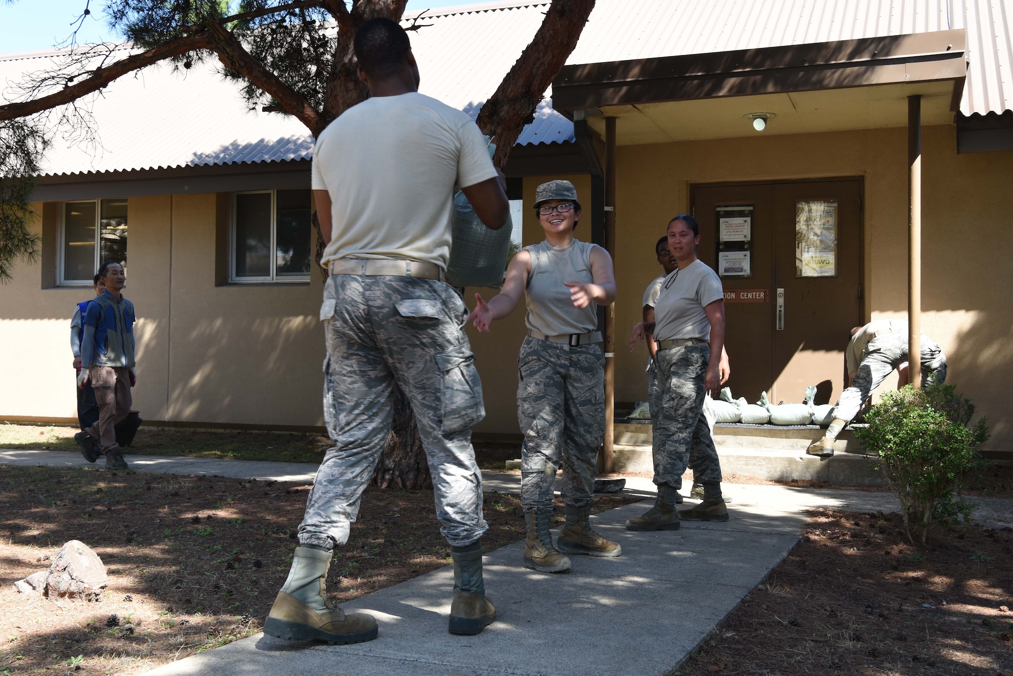 U.S. Airmen assigned to the 8th Force Support Squadron, pass off sand bags at Kunsan Air Base, Republic of Korea, Aug. 22, 2018. Airmen from the 8th Fighter Wing cleaned-up loose items, filled sand bags, and took other preparatory actions as Typhoon Soulik approaches the Korean peninsula. (U.S. Air Force photo by Staff Sgt. Jasmonet D. Jackson)