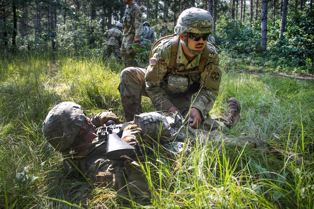 A soldier applies a tourniquet to the leg of a squad member during Operation Lethal Warrior.