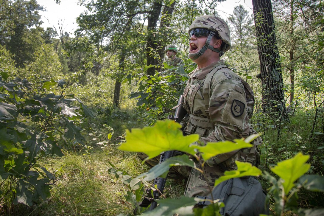 A soldier yells follow-on instructions to his squad members while conducting a patrol.