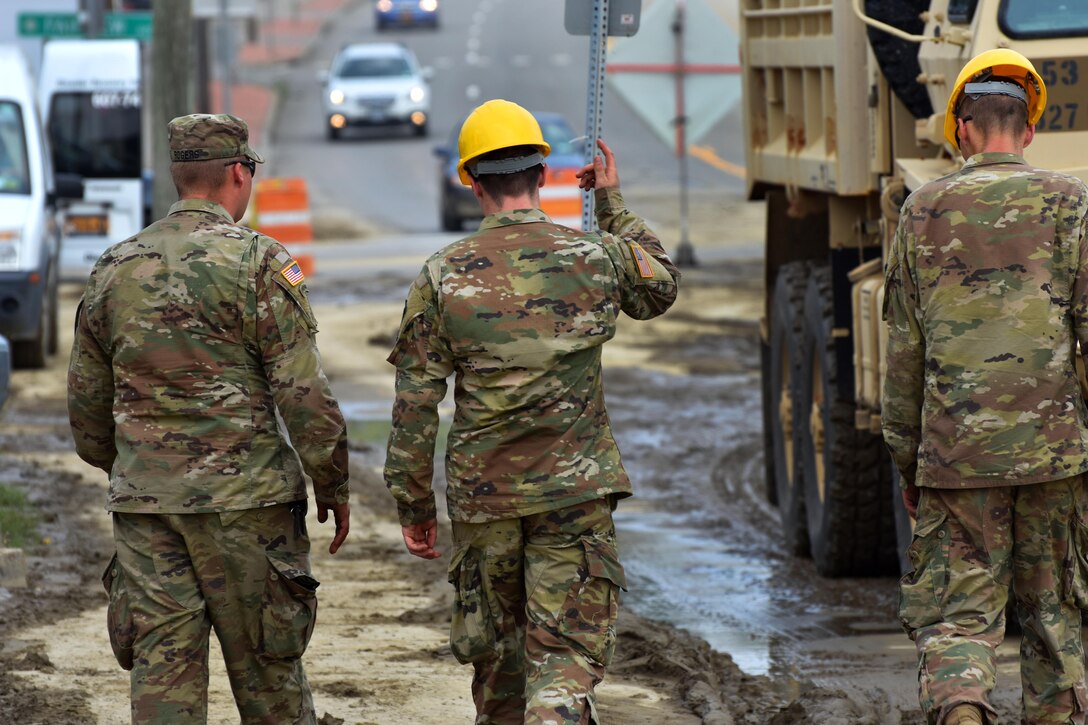 Soldier’s discus the progress of clearing mud and debris from streets.