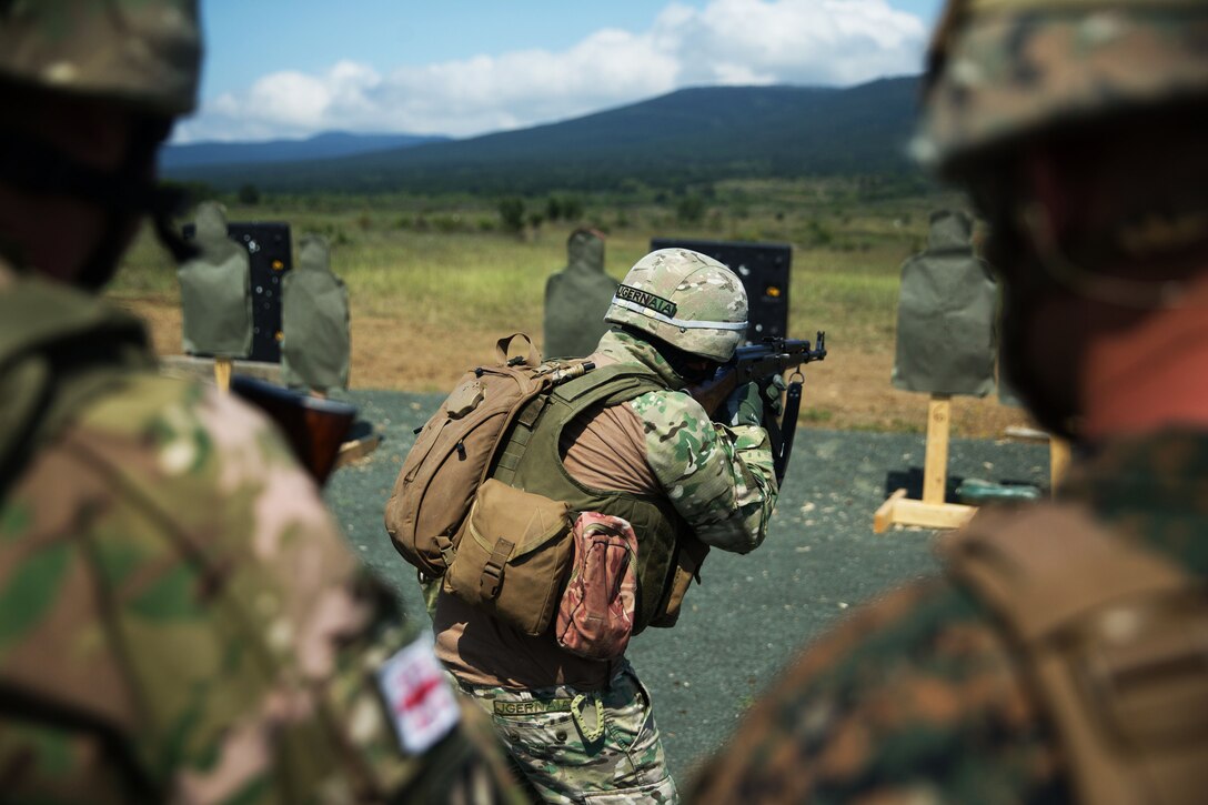 A member of the Georgian armed forces executes a combat marksmanship program range while other soldiers and U.S. Marines watch during Exercise Platinum Lion 18.