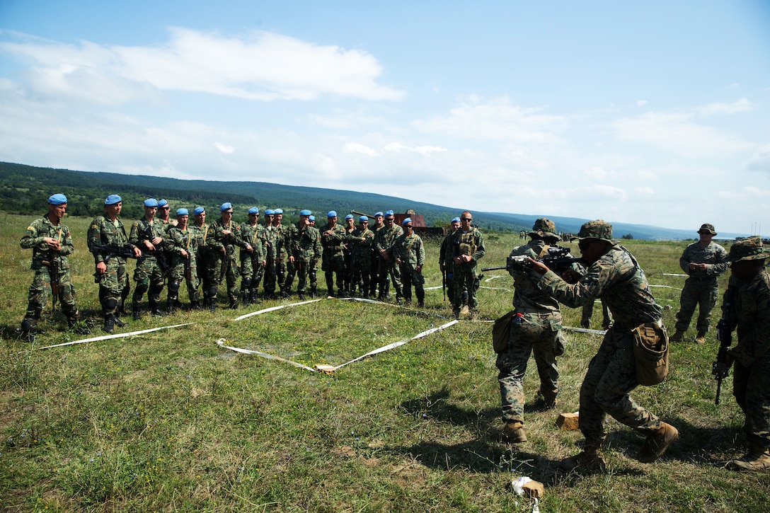 Members of the Albanian armed forces watch as a U.S. Marine assigned to Black Sea Rotational Force 18.1 demonstrate house techniques.