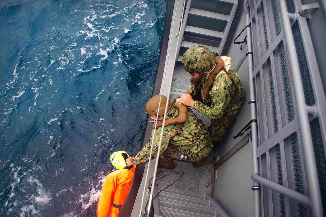 Sailors rescue a training mannequin during a man overboard drill.