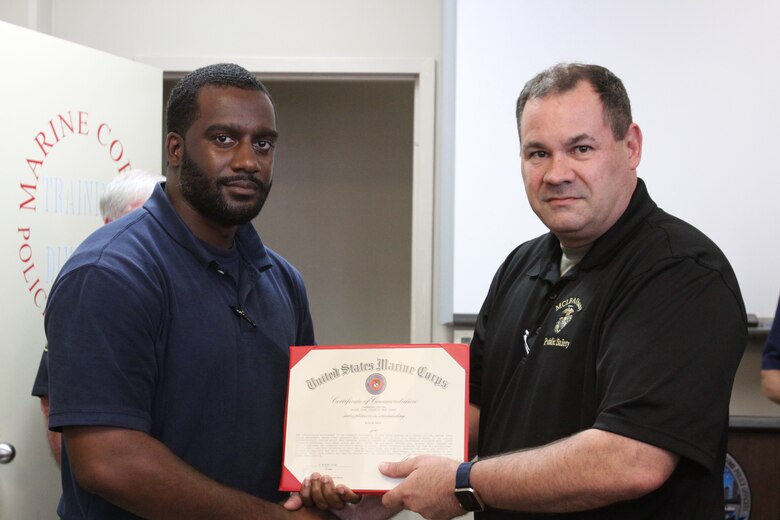 Marine Corps Logistics Base Albany Public Safety Director Paul Ellis (right) presented a certificate of commendation to MCPD officer Willie Hall, (left) August 21. Hall prevented a potential tragedy while responding to a house fire. Hall's dedicated attention to duty, not only saved lives but directly impacted the safety and security of neighboring residents and their families. (U.S. Marine Corps photo by Re-Essa Buckels)