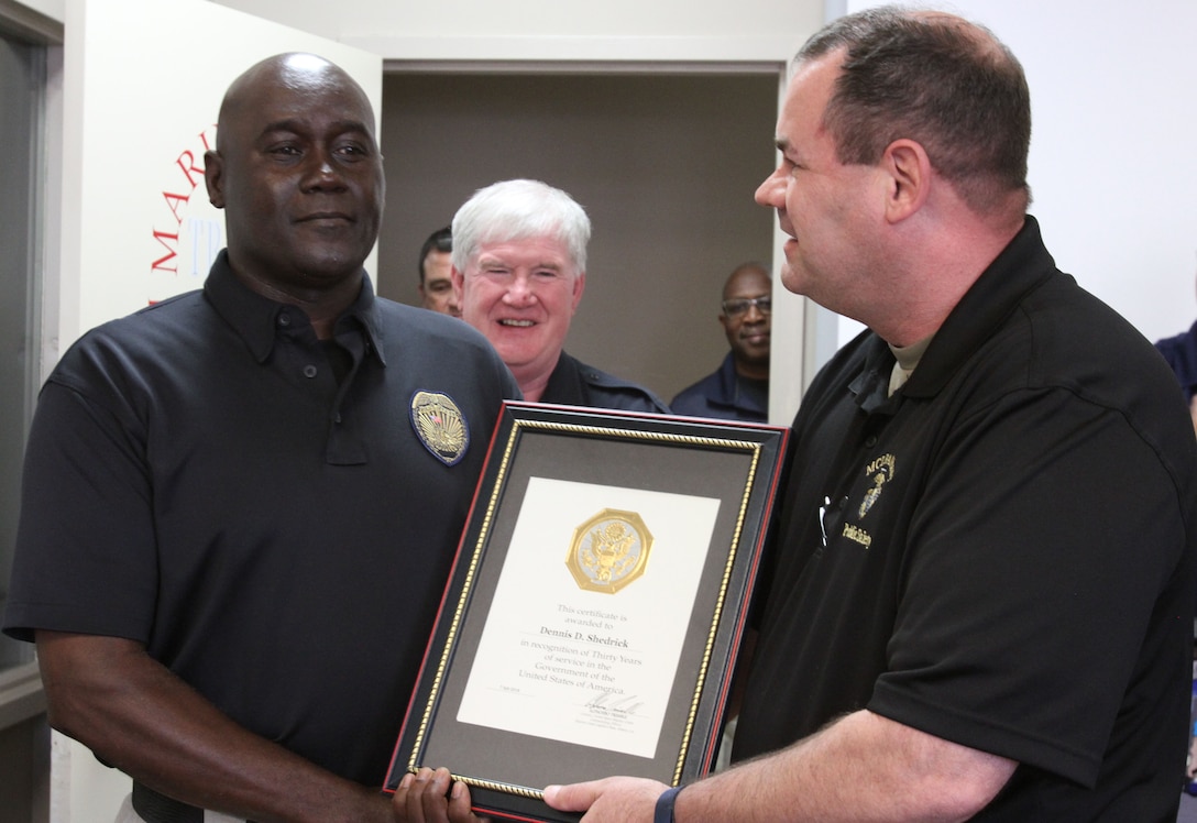 Marine Corps Logistics Base Albany Public Safety Director Paul Ellis (right) presented a 30-year length of service award to MCPD officer Dennis Shedrick (left), August 21. (U.S. Marine Corps photo by Re-Essa Buckels)