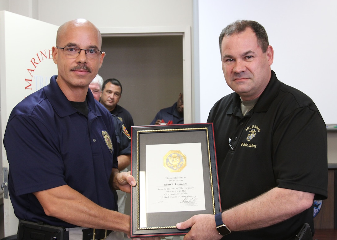 Marine Corps Logistics Base Albany Public Safety Director Paul Ellis (right) presented a 30-year length of service award to MCPD Deputy Chief Sean Lamonzs (left), August 21. (U.S. Marine Corps photo by Re-Essa Buckels)