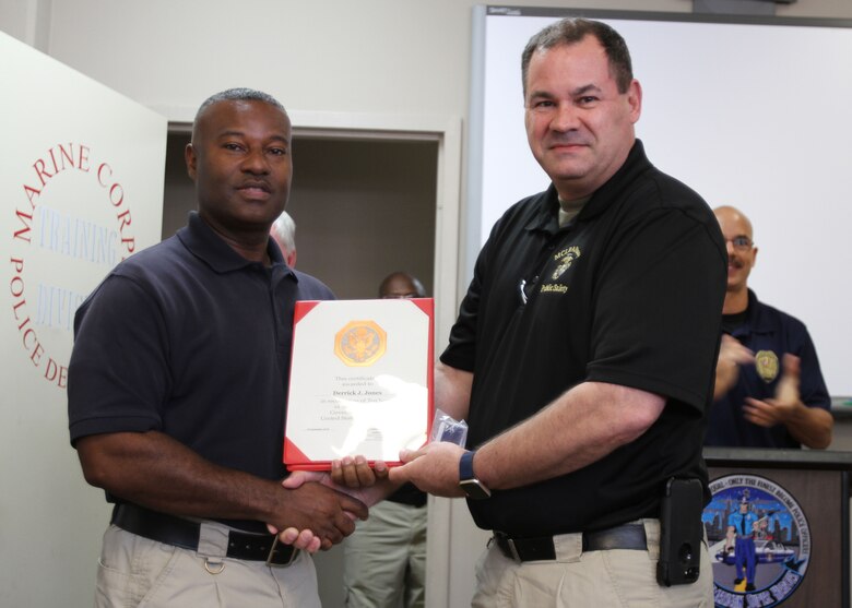 Marine Corps Logistics Base Albany Public Safety Director Paul Ellis (right) presented a 10-year length of service award to MCPD officer Derrick Jones (left), August 21. (U.S. Marine Corps photo by Re-Essa Buckels)