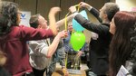 DCMA and DCAA employees build a tower with string and ballons as a team-building exercise.