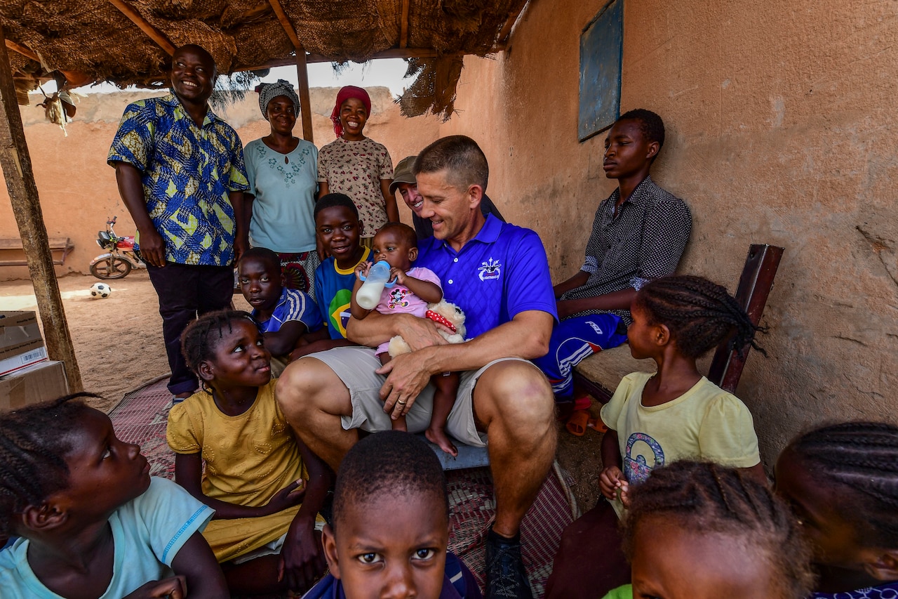 Air Force Col. Trey Rawls, 435th Air Expeditionary Wing commander, holds a baby at an orphanage in Agadez, Niger.