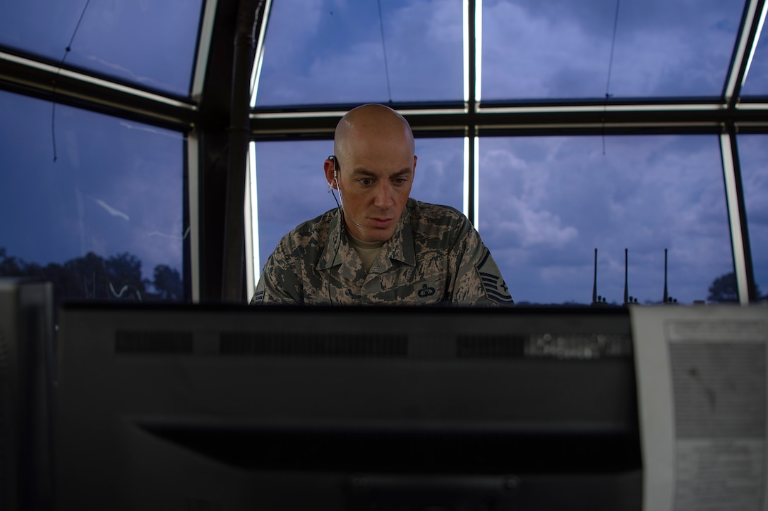 Master Sgt. Christopher Dyer, 23d Operations Support Squadron air traffic controller watch supervisor, looks over his computer, Aug. 15, 2018, at Moody Air Force Base, Ga. Air traffic controllers direct runway operations by sequencing and separating aircraft, issuing safety alerts, ensuring the safety of pilots and managing the expeditious flow of traffic. (U.S. Air Force photo by Airman Taryn Butler)