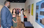 Willie White Jr., Fort Sam Houston Independent School District board of trustees president, talks to Laura DeLeon, a student at Cole High School, as he views one of DeLeon’s photos that is displayed in a gallery of photos taken by Cole students during a reception Aug. 9 at the Fort Sam Houston Museum.