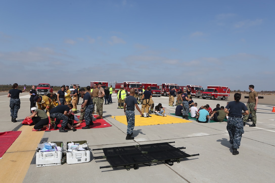 Marines with Marine Corps Air Station Miramar Aircraft Rescue and Fire Fighting, Navy Corpsman with MCAS Miramar’s Branch Medical Clinic and Firefighters with the MCAS Miramar Fire Department work together to transport and provide medical assistance to victims during an exercise at MCAS Miramar, Aug 16. 2018. Emergency response exercises are conducted to rehearse response times, validate existing standard operating procedures, fulfill annual training requirements, and validate the effectiveness of MCAS Miramar emergency services. (U.S. Marine Corps photo by Sgt. Daniel Auvert.)