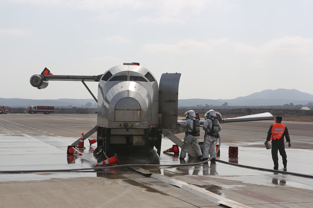 Marines with Marine Corps Air Station Miramar Aircraft Rescue and Fire Fighting extinguish a fire on a mobile burn unit during an exercise at MCAS Miramar, Aug 16. 2018. Emergency response exercises are conducted to rehearse response times, validate existing standard operating procedures, fulfill annual training requirements and validate the effectiveness of MCAS Miramar emergency services. (U.S. Marine Corps photo by Sgt Daniel Auvert.)