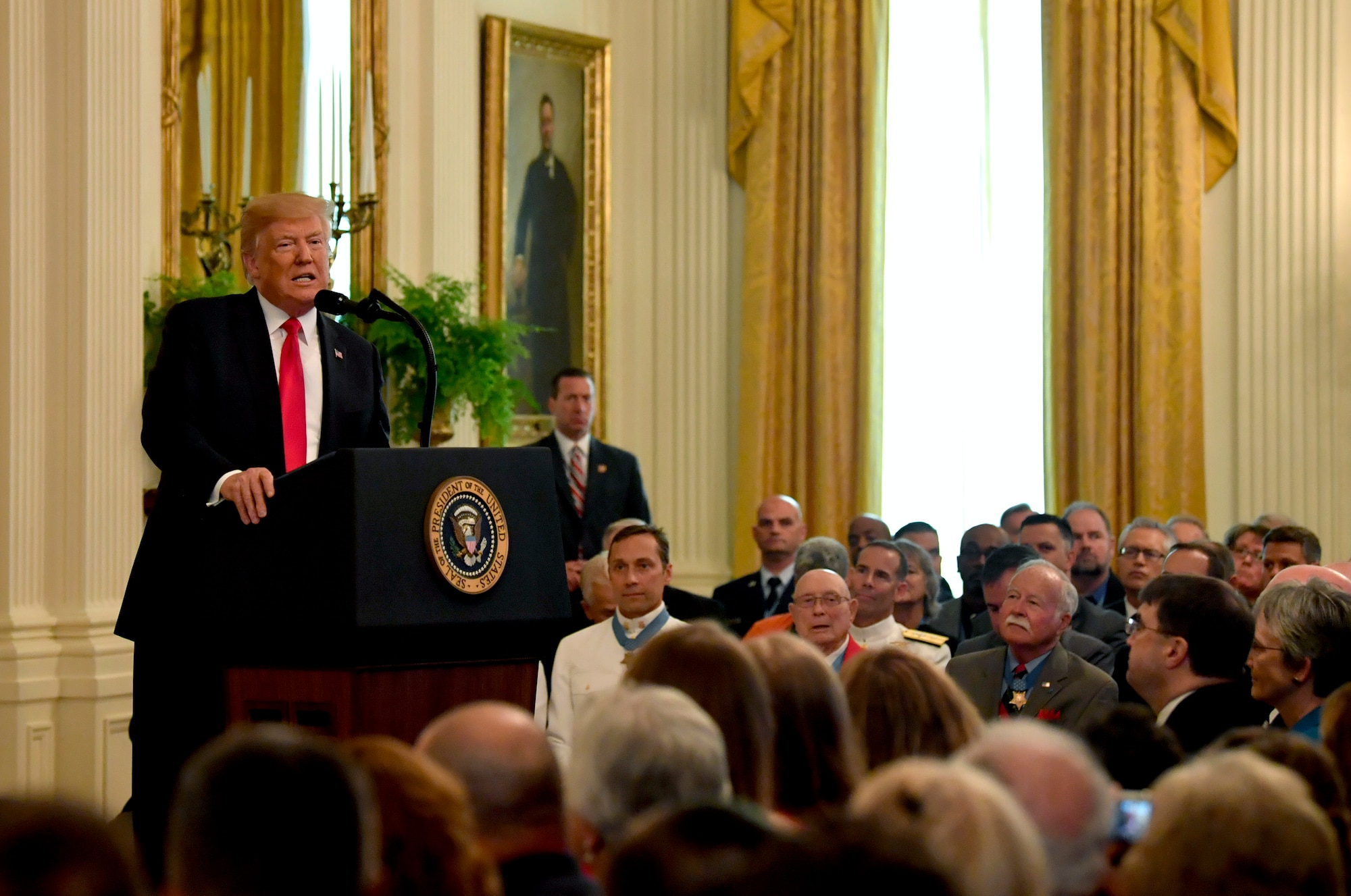 President Donald J. Trump gives his remarks during the Medal of Honor ceremony for Tech. Sgt. John Chapman at the White House in Washington, D.C., Aug. 22, 2018. Chapman was posthumously awarded the Medal of Honor for actions on Takur Ghar mountain in Afghanistan on March 4, 2002, when his elite special operations team was ambushed by the enemy and came under heavy fire from multiple directions. Chapman immediately charged an enemy bunker through thigh-deep snow and killed all enemy occupants. Courageously moving from cover to assault a second machine gun bunker, he was injured by enemy fire. Despite severe wounds, he fought relentlessly, sustaining a violent engagement with multiple enemy personnel before making the ultimate sacrifice. With his last actions, he saved the lives of his teammates. (U.S. Air Force photo by Wayne A. Clark)