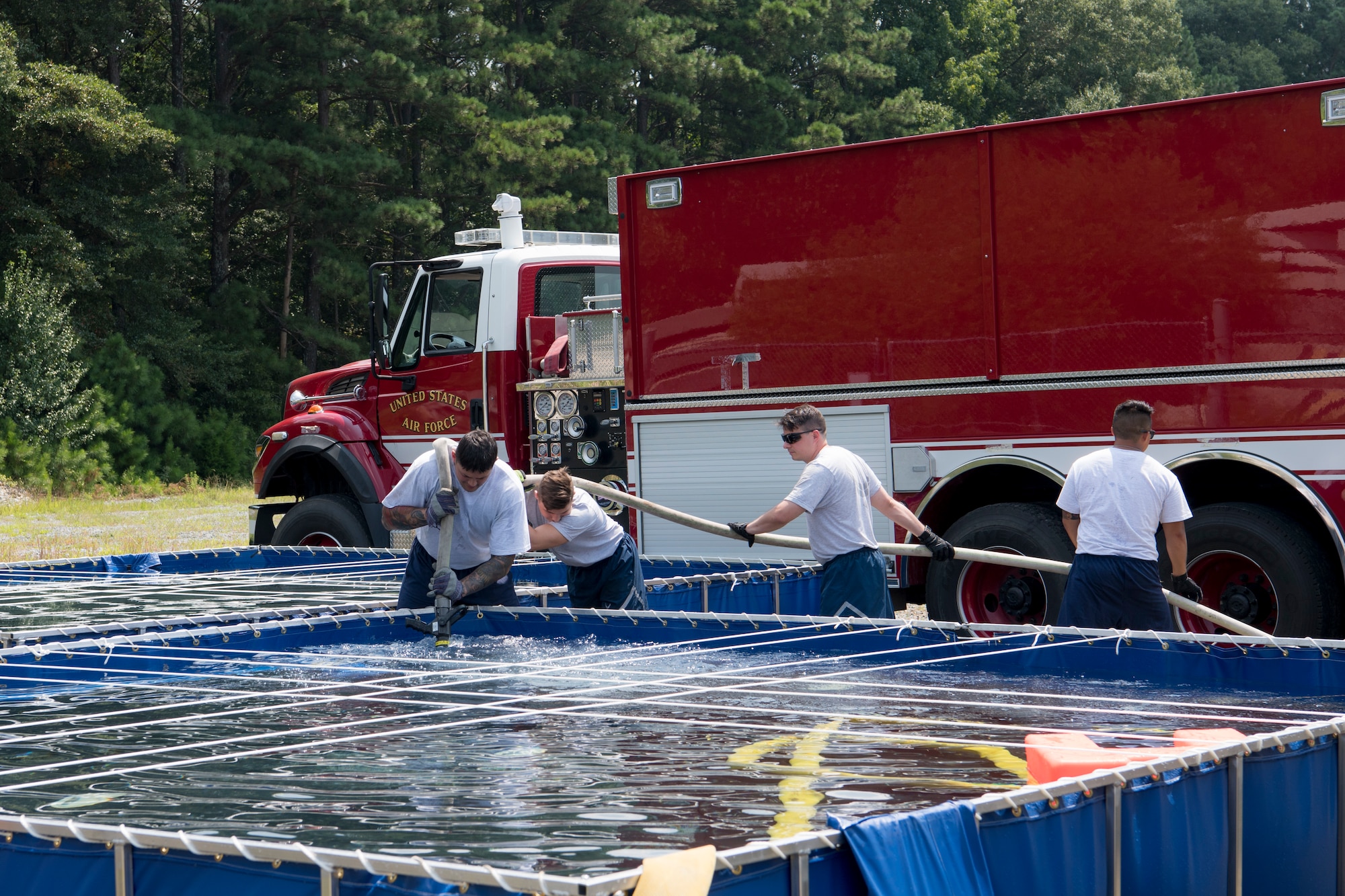 U.S. Air Force Reserve firefighters pump water into their trucks in preparation for their next simulated fire training event during Patriot Warrior at Dobbins Air Reserve Base, Georgia, August 14, 2018. Left to right: Senior Airman Warren Duke with the 624th Civil Engineer Squadron from Joint Base Pearl Harbor-Hickam, Hawaii, Senior Airman Matthew Southwick with the 446th CES from Joint Base Lewis-McChord, Washington, and Master Sgt. Robert 514th CES from Joint Base McGuire-Dix-Lakehurst, New Jersey. Patriot Warrior is an Air Force Reserve exercise designed to prepare Reserve Citizen Airmen for world-wide deployments and provides knowledge and experience to strengthen home station training programs. (U.S. Air Force photo by Master Sgt. Theanne Herrmann)