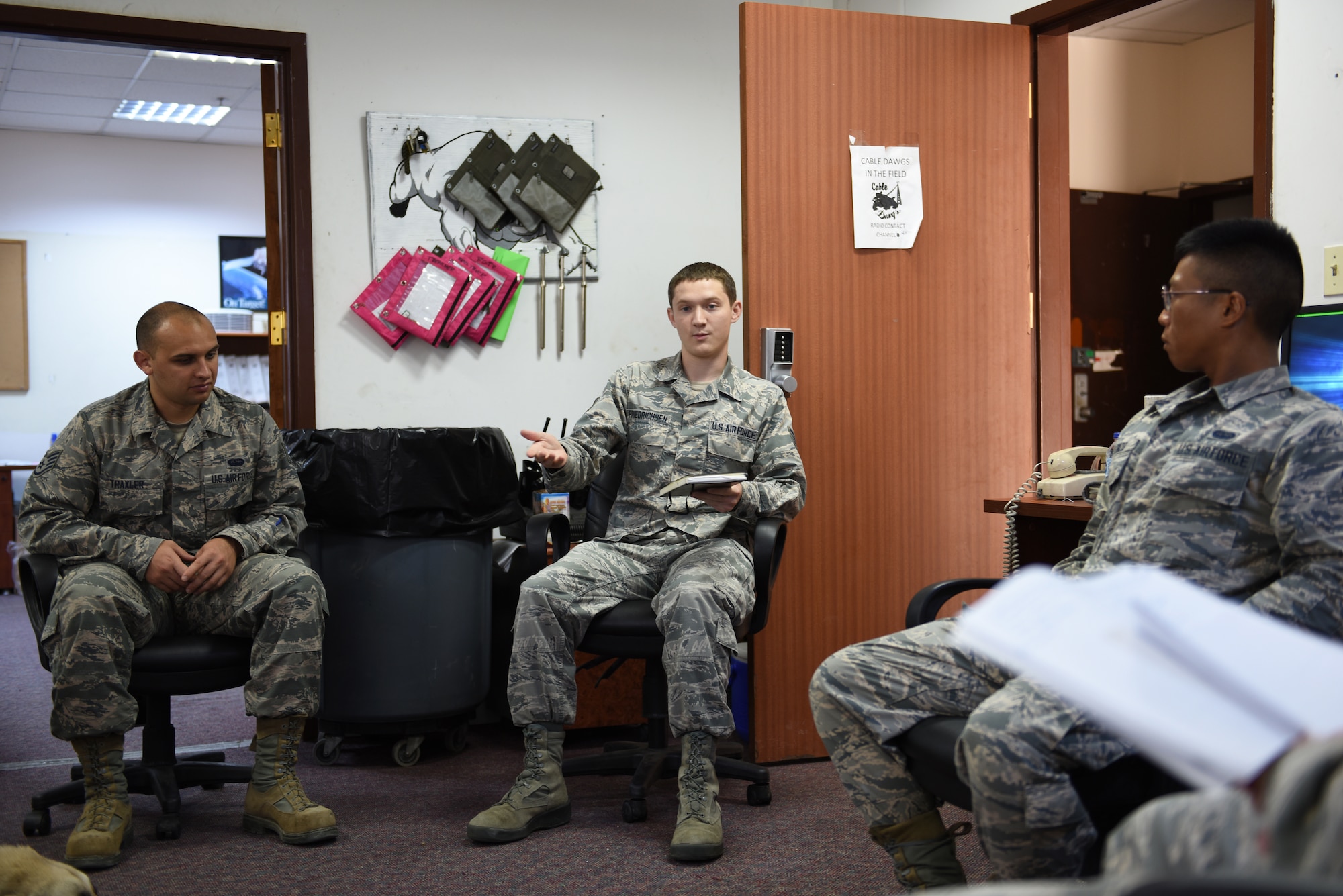 Members of the communication squadron brief each other on workplace safety