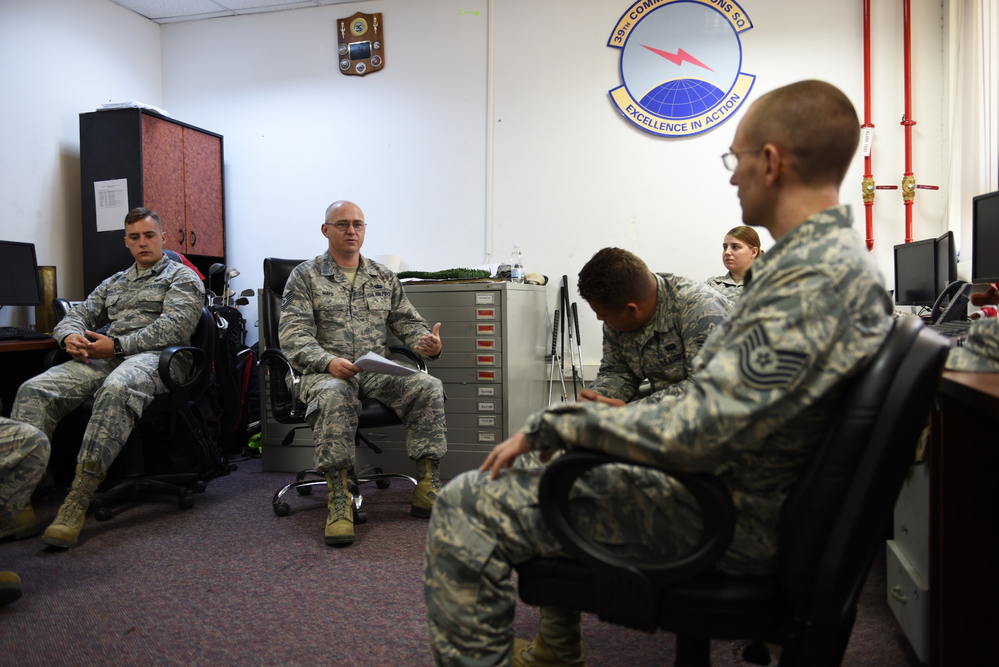 Members of the communication squadron brief each other on safety in the workplace.