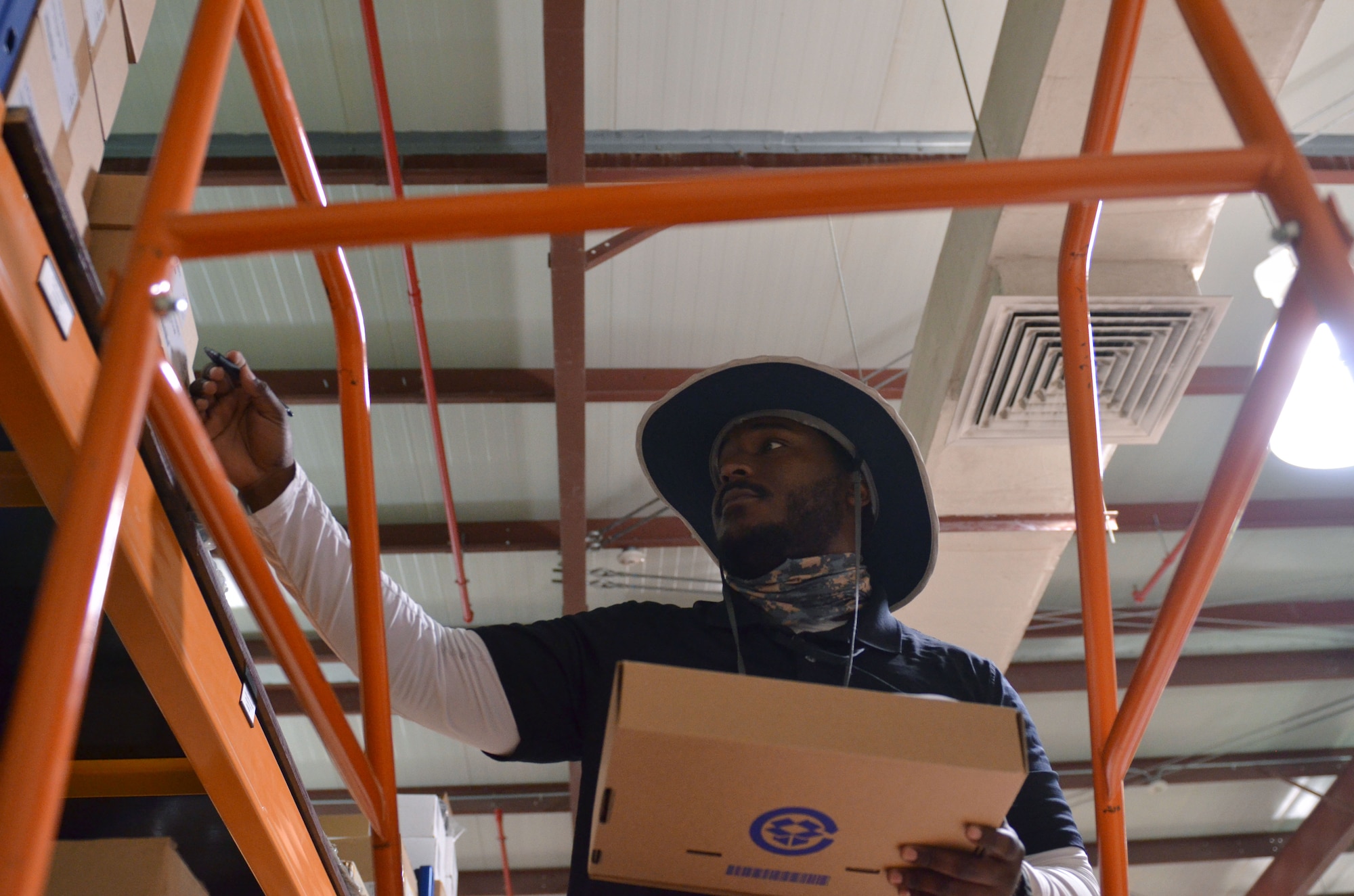 Artemas Tucker, a contracted hardware support technician with the 609th Expeditionary Air Communication Squadron (EACOMS), checks inventory of the EACOMS warehouse Aug. 8, 2018, at Al Udeid Air Base, Qatar. The warehouse is the sole distributing center for the Combine Air Operations Center and tracks 8,500 pieces of equipment. (U.S. Air Force photo by Staff Sgt. Caitlin Conner)
