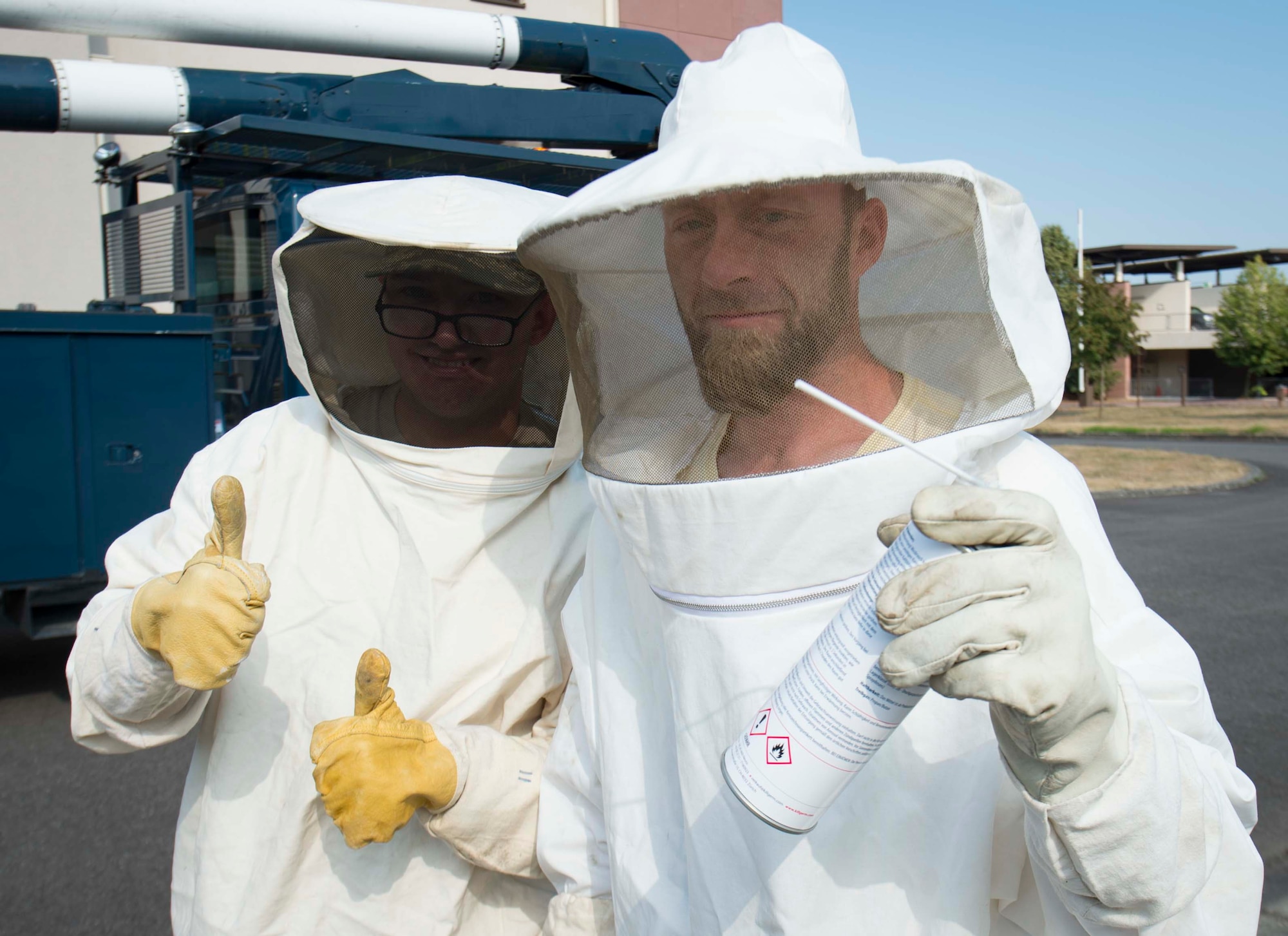 Arturo Basile, right, 786th Civil Engineer Squadron Pest Management specialist, poses alongside a 786th CES electrician on Ramstein Air Base, Germany, Aug. 7, 2018. The 786th CES electricians lend Pest Management equipment to access hives and nests, ensuring Ramstein remains pest-free. (U.S. Air Force photo by Senior Airman Elizabeth Baker)