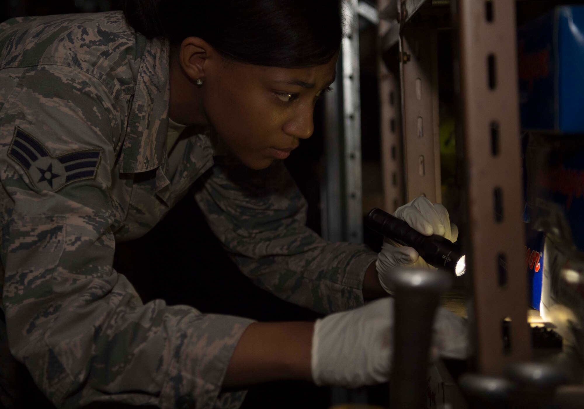 U.S. Air Force Senior Airman Arielle Howze, 786th Civil Engineer Squadron Pest Management technician, inspects a storage area for mice on Ramstein Air Base, Germany, Aug. 7, 2018. Ramstein has the largest Pest Management shop in U.S. Air Forces in Europe-Air Forces Africa, with a staff of two civilians and seven Airmen servicing more than 55,000 people in the Kaiserslautern Military Community. (U.S. Air Force photo by Senior Airman Elizabeth Baker)