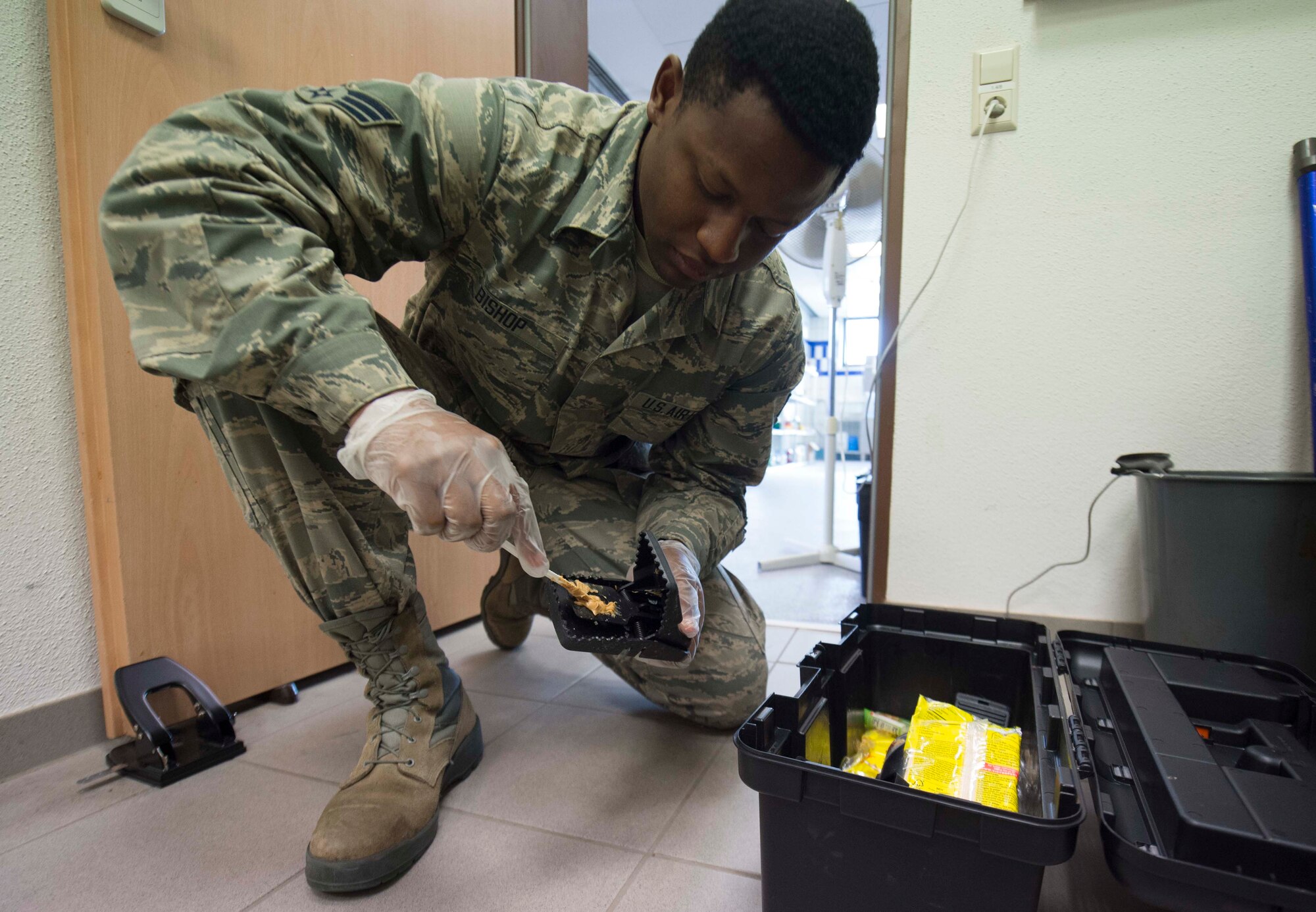 U.S. Air Force Senior Airman William Bishop, 786th Civil Engineer Squadron Pest Management technician, baits a rodent trap with peanut butter on Ramstein Air Base, Germany, Aug. 7, 2018. Pest Management specialists are responsible for controlling and preventing pest infestations. (U.S. Air Force photo by Senior Airman Elizabeth Baker)