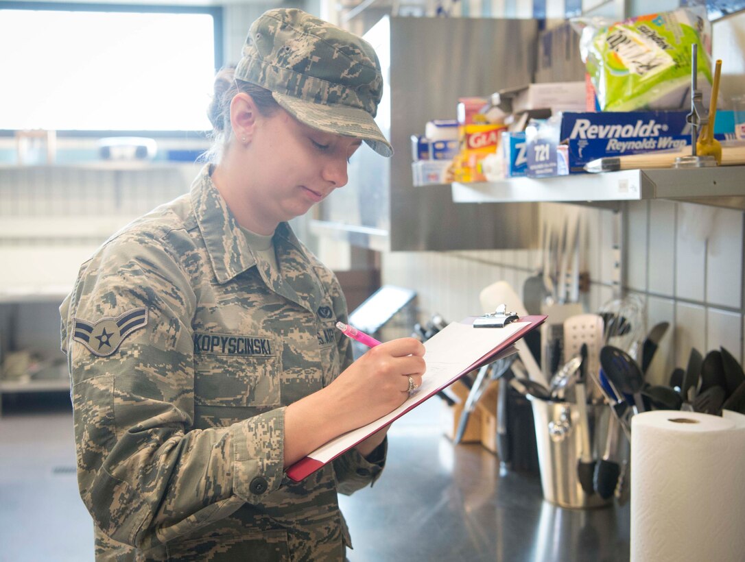 U.S. Air Force Airman 1st Class Sarah Kopyscinski, 786th Civil Engineer Squadron Pest Management apprentice, performs a preventive management inspection in a kitchen on Ramstein Air Base, Germany, Aug. 7, 2018. Pest Management inspects approximately 60 food handling facilities, and completes monthly, base-wide, random inspections to ensure roaches, mice, and rats aren't lingering in the Ramstein facilities. (U.S. Air Force photo by Senior Airman Elizabeth Baker)