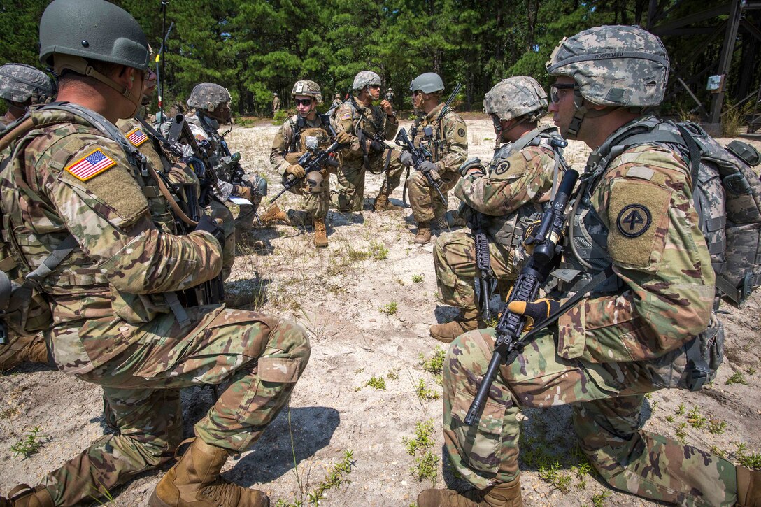 Soldiers discus final firing positions before conducting a live-fire exercise.